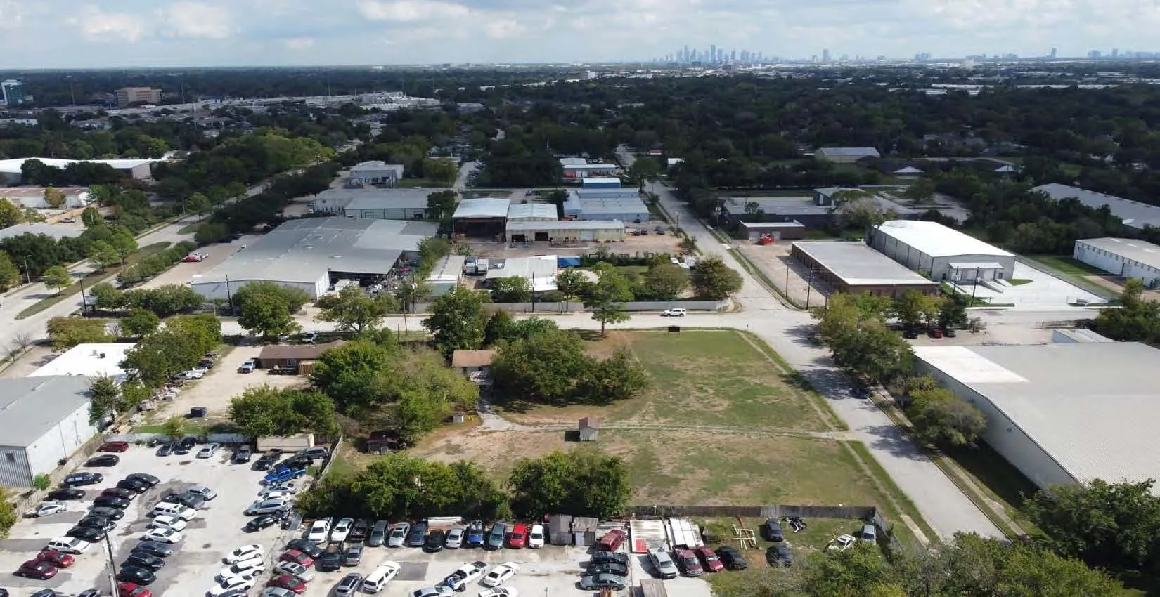 Aerial view of the Dayco Heights site, an open infill lot in Spring Branch, with downtown Houston on the horizon