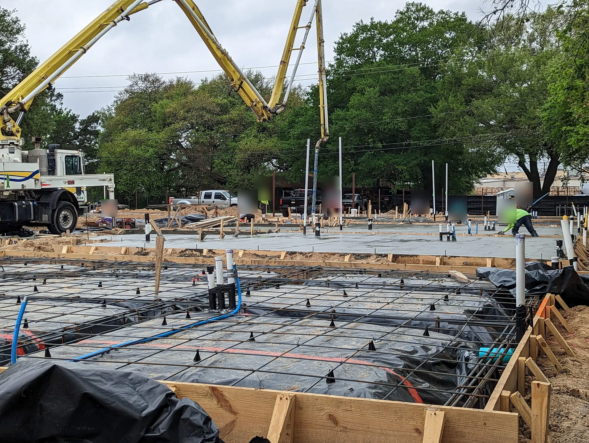 Slab foundation forms with rebar while a concrete pump truck works